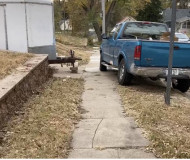 The image shows a sidewalk blocked with a large blue truck